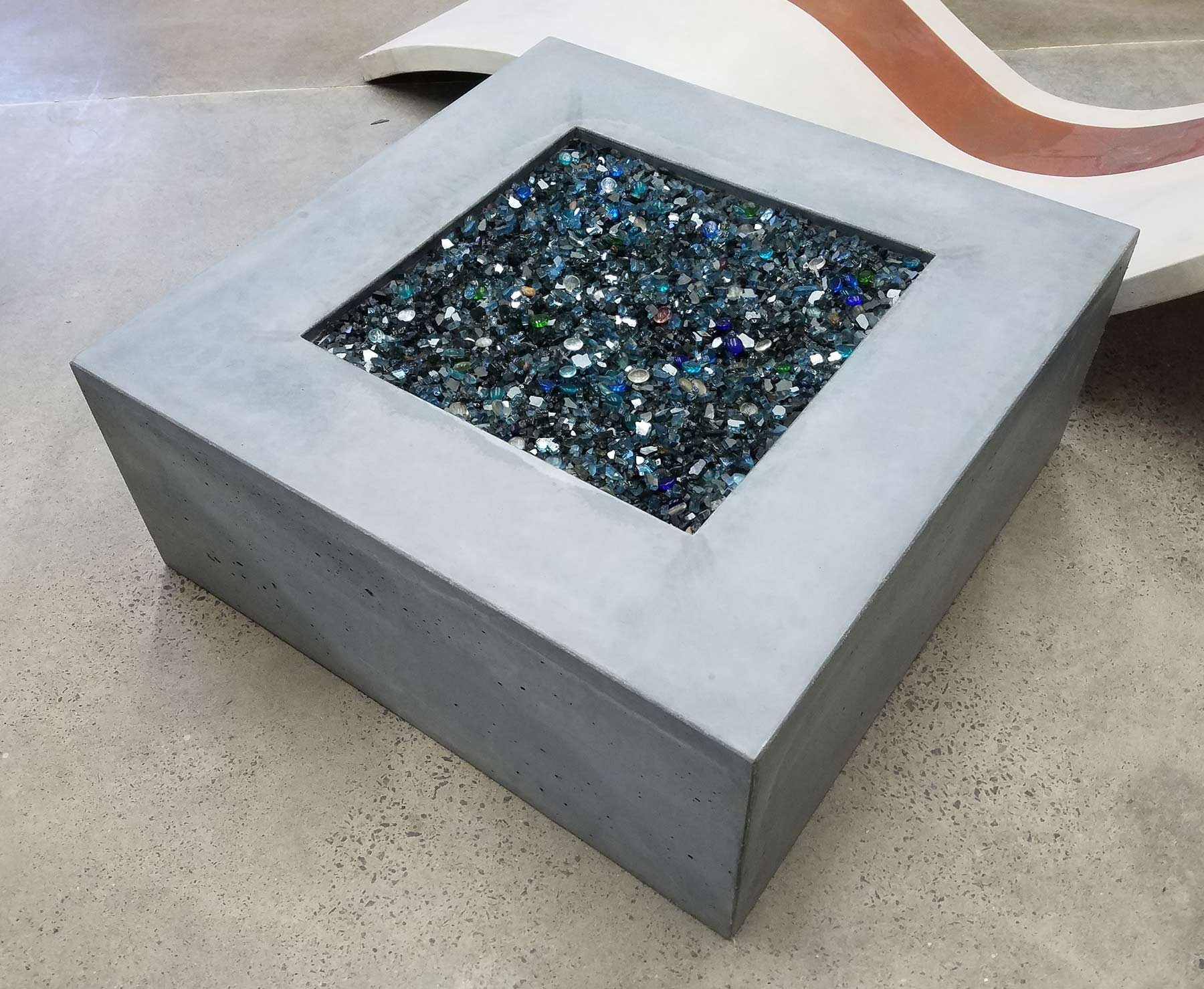 square concrete firepit with translucent stones, gas powered