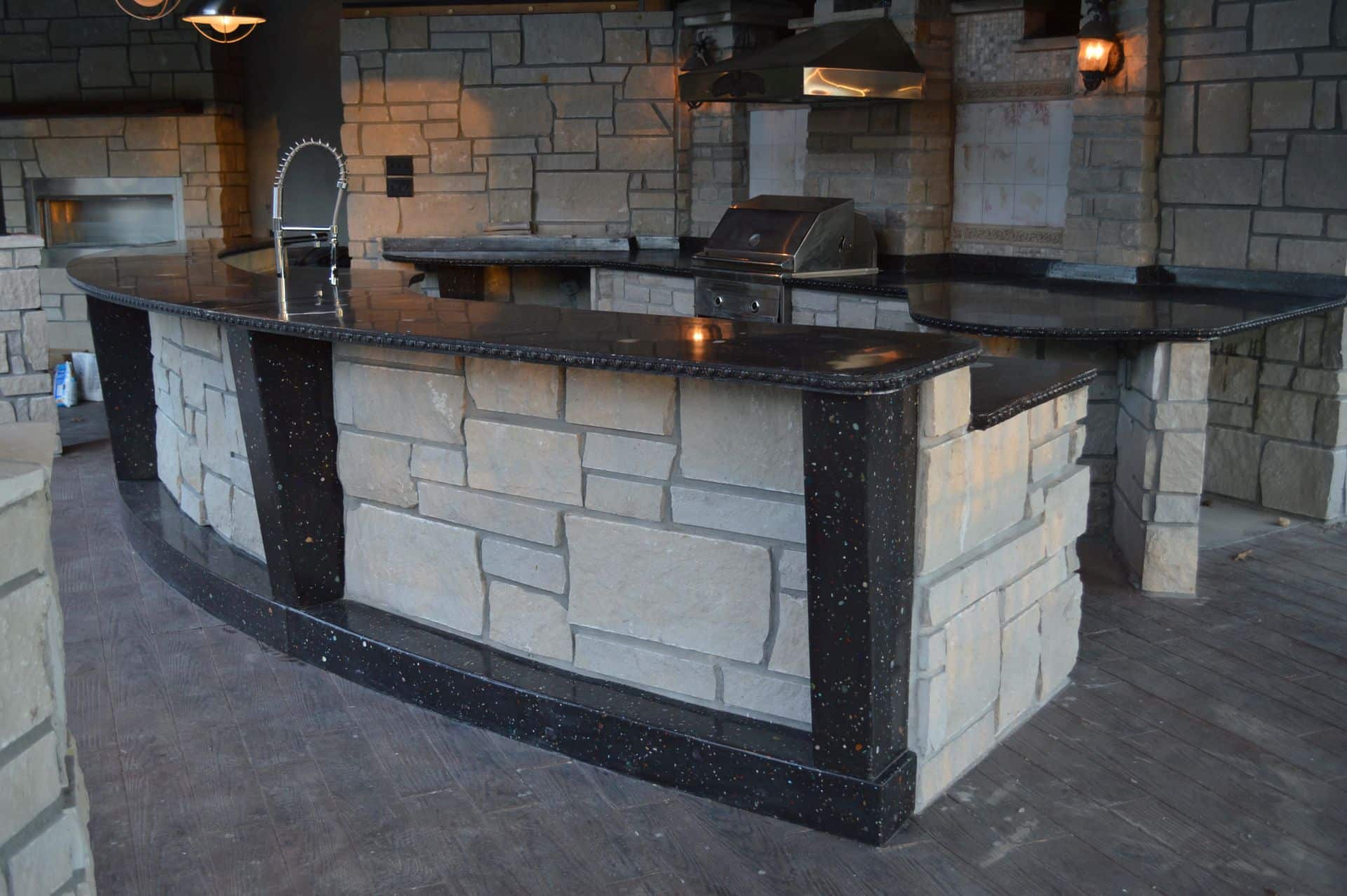 Distant 45 degree angle image of outdoor concrete counter, grill behind