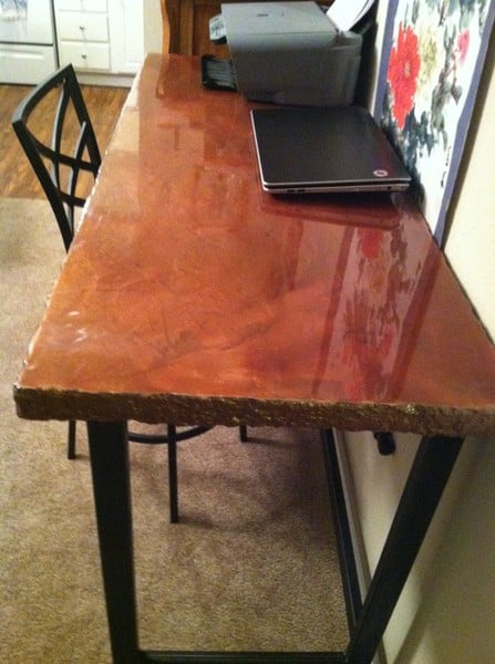 light brown concrete desk elevated by iron base